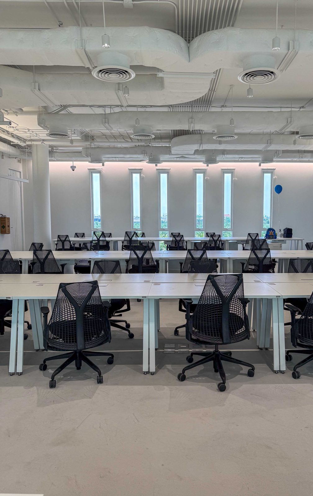 Open-plan office with long desks and rows of Sayl chairs