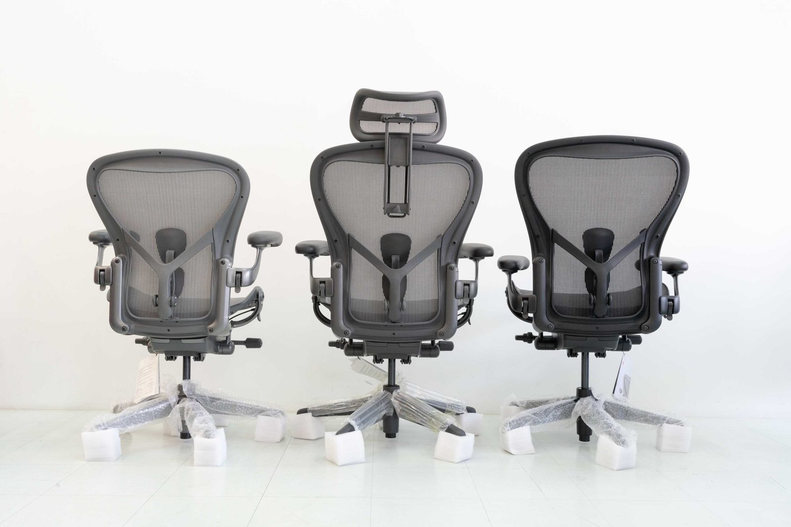 Three Aeron chairs seen from behind in the showroom