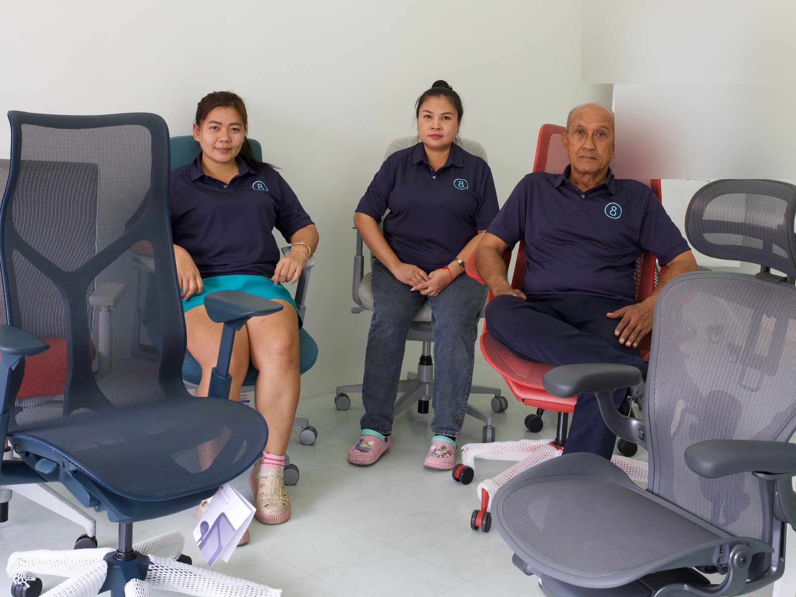 Team members seated on Herman Miller chairs in the showroom